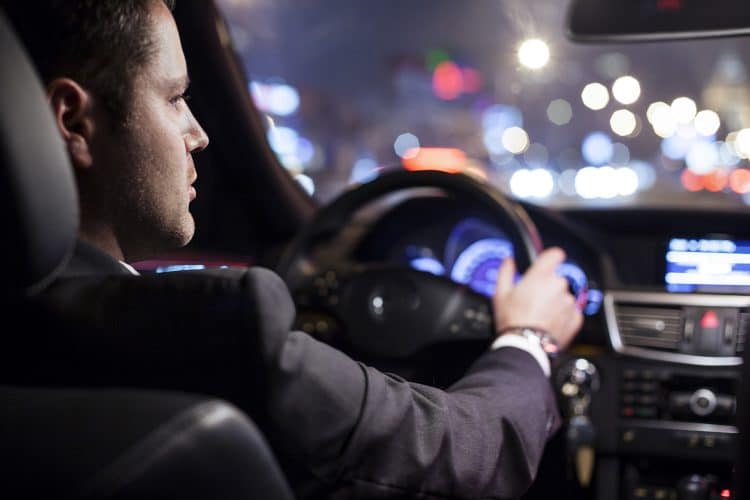 businessman driving a car at night
