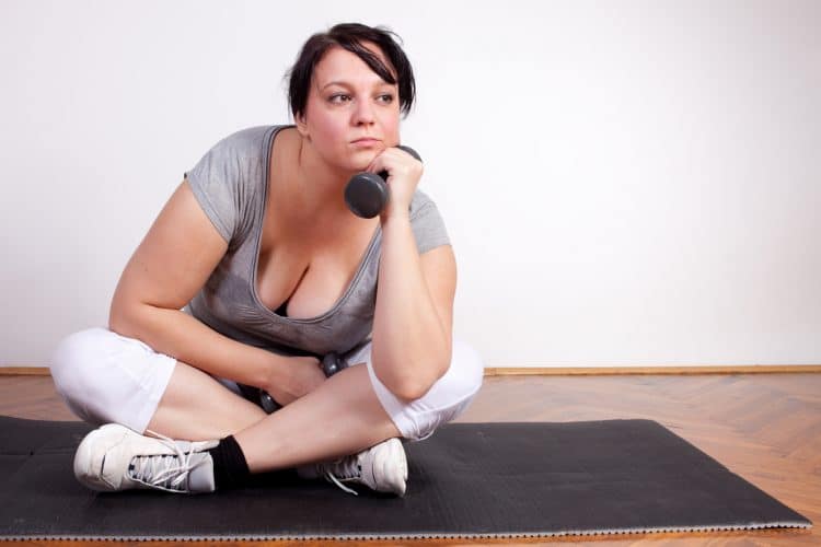Overweight woman is fed up and tired of exercising