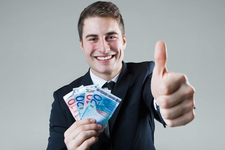 Portrait of young man in formalwear holding money.
